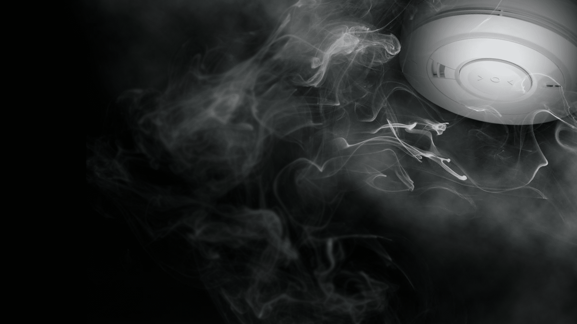 dark background image showing smoke rising to Aico smoke alarm on cieling